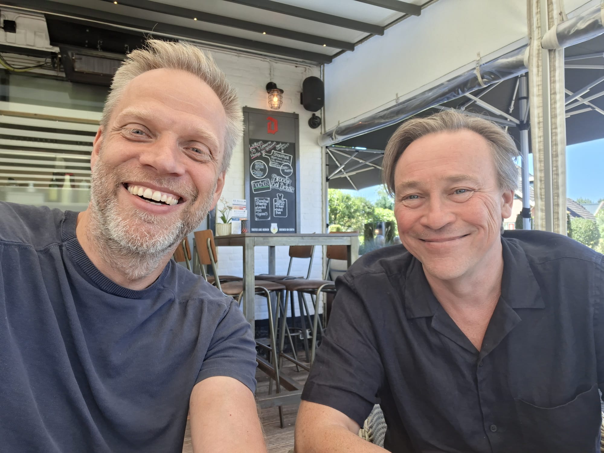 Trinko Keen en Guts Wissema samen aan tafel op een terras